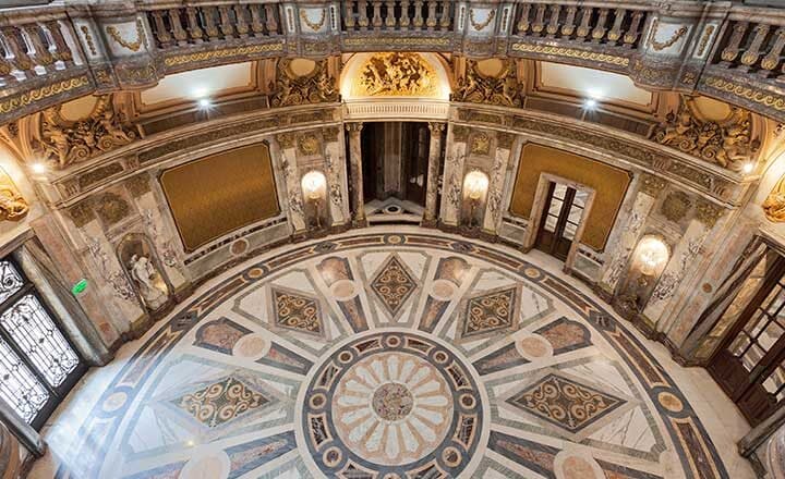 El Gran Hall de Honor visto desde arriba: la rotonda con piso de mármoles en dibujo radiado, la balaustrada del piso superior y los frisos dorados de la cúpula.